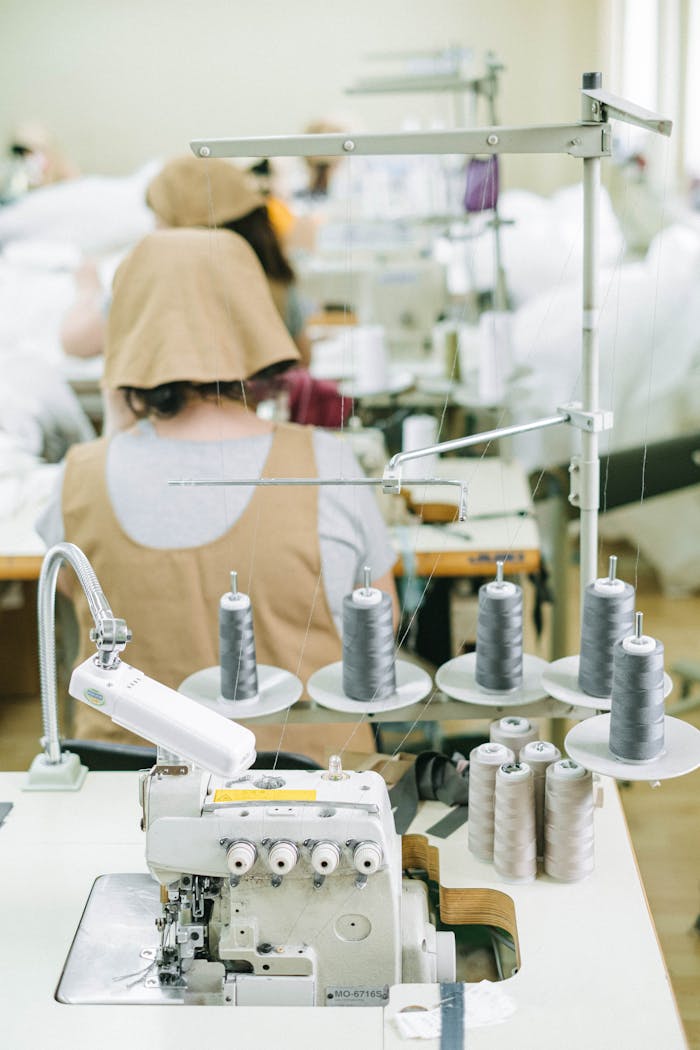 Sewing machines and workers in a textile factory, highlighting industrial manufacturing processes.